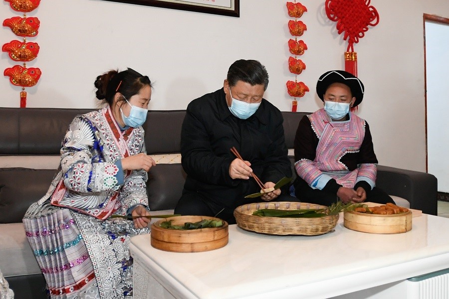 2021年2月3日下午，習近平在貴州畢節(jié)市黔西縣新仁苗族鄉(xiāng)化屋村苗族村民趙玉學家，同一家人邊聊家常邊制作當?shù)貍鹘y(tǒng)節(jié)日食品黃粑。新華社記者 李學仁 攝