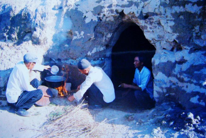 1983年，“六老漢”一代治沙人在“地窩子”生活做飯。新華社發(fā)（八步沙林場(chǎng)供圖）